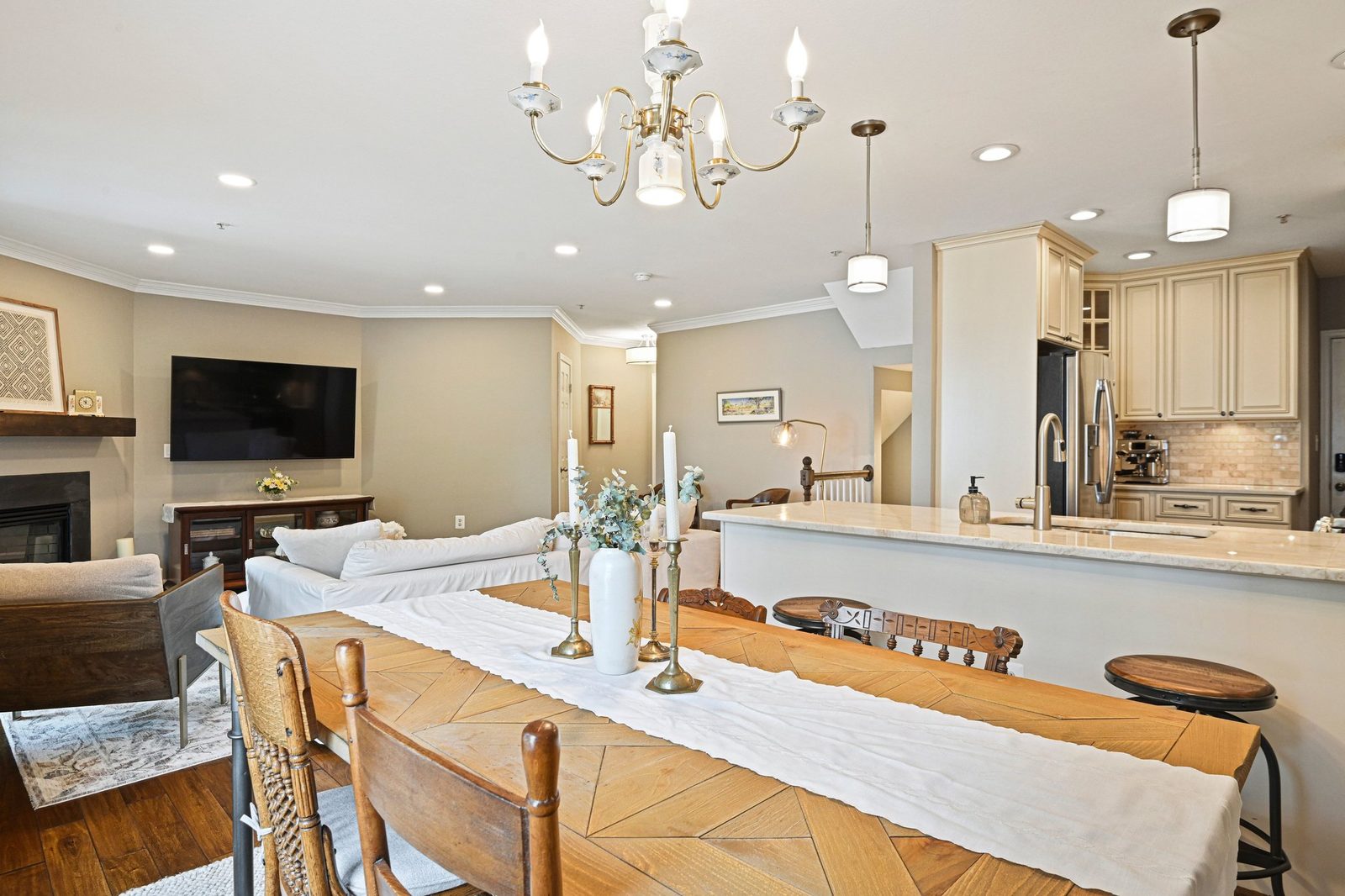 Open living and dining area with fireplace, kitchen peninsula, hardwood floors