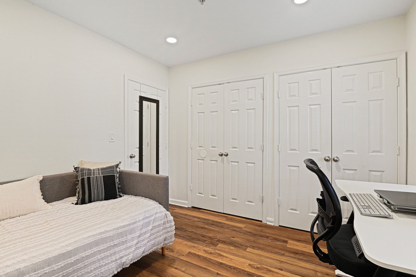 Second bedroom with two double closets, wood-look floors and daybed