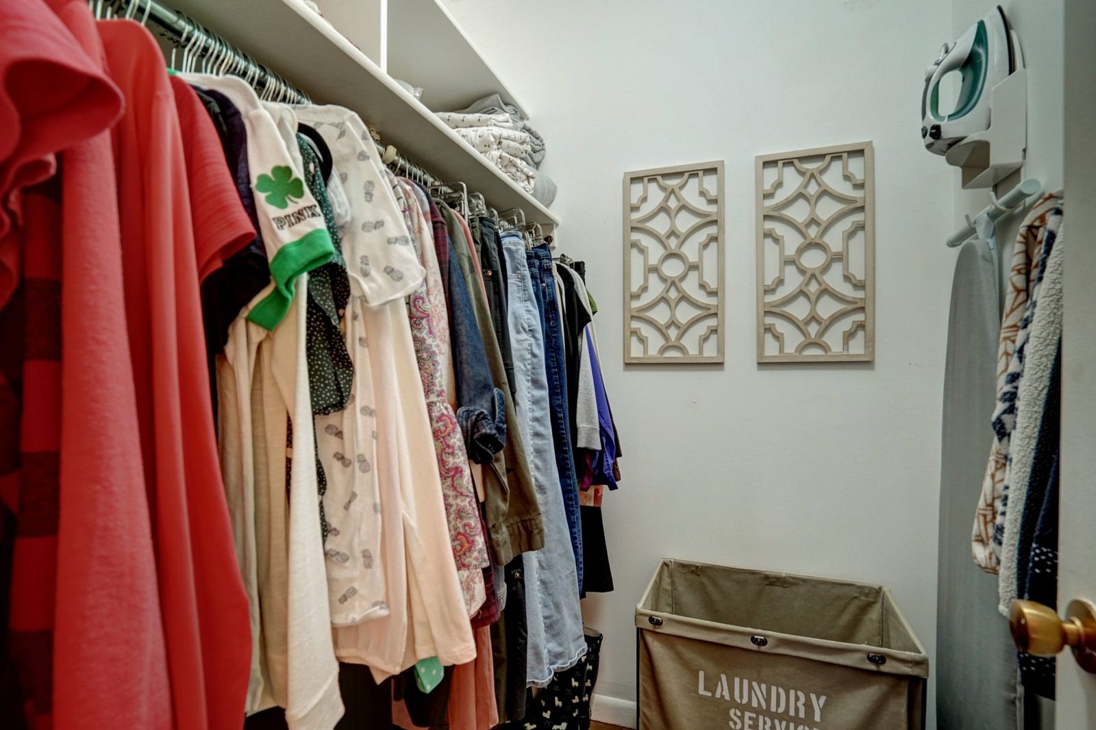 Walk-in closet with double hanging rods and overhead shelf