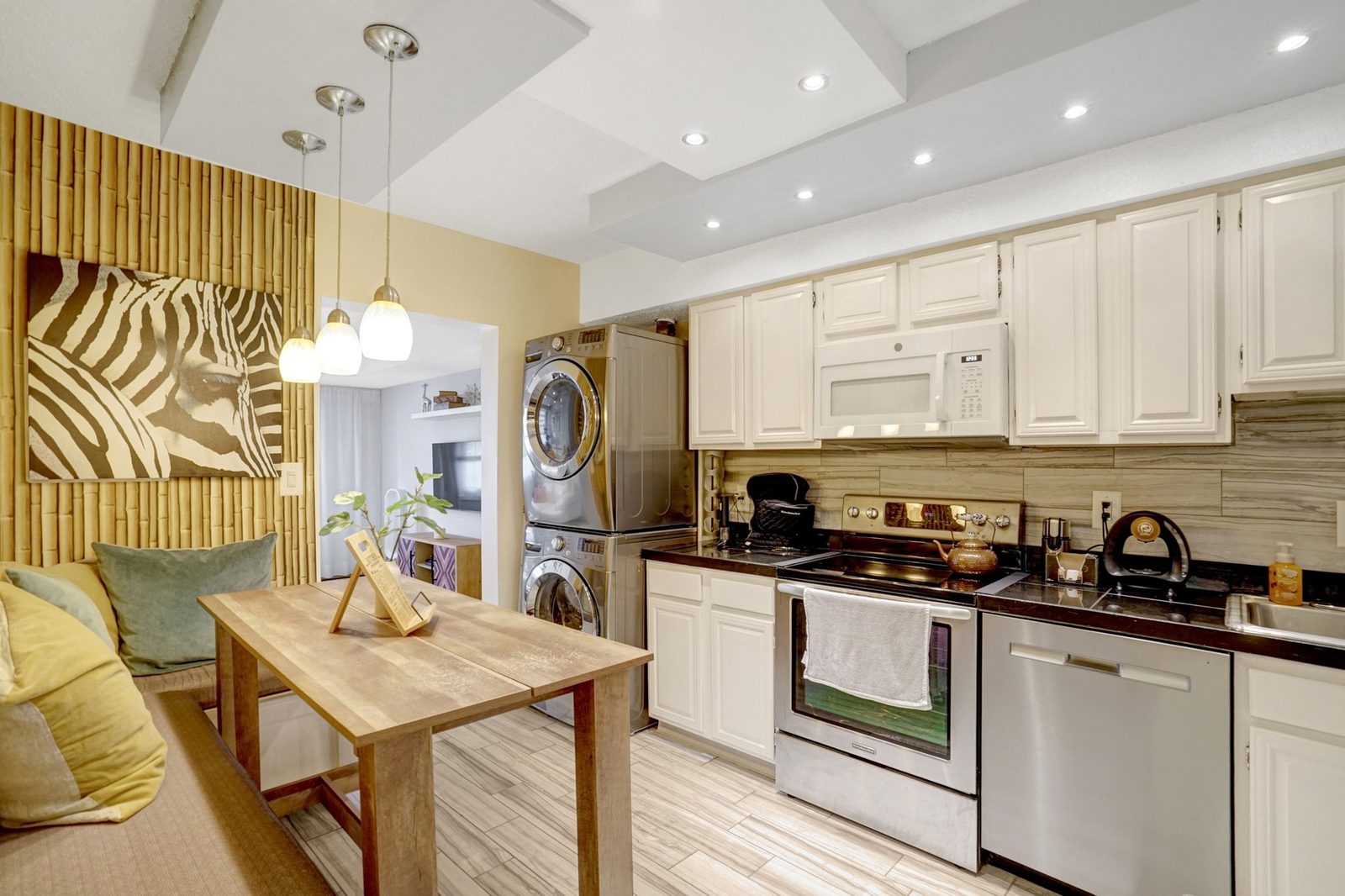 Kitchen with stacked washer and dryer beside a breakfast table