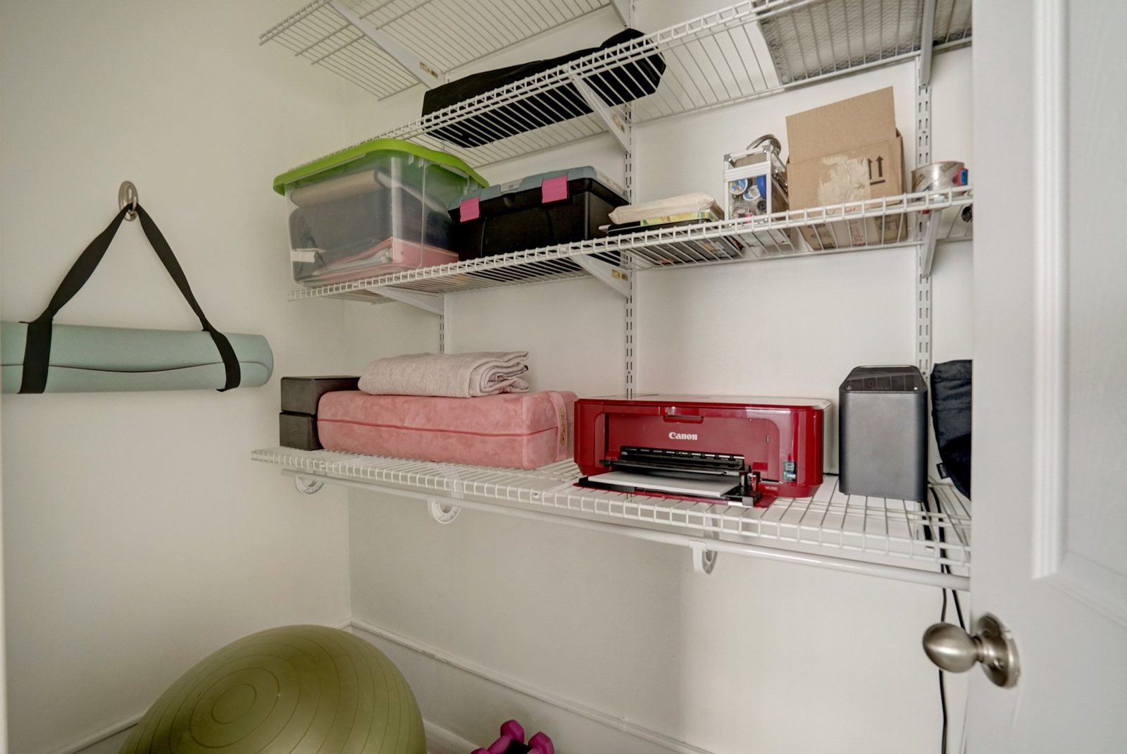 Walk-in storage closet lined with white wire shelving