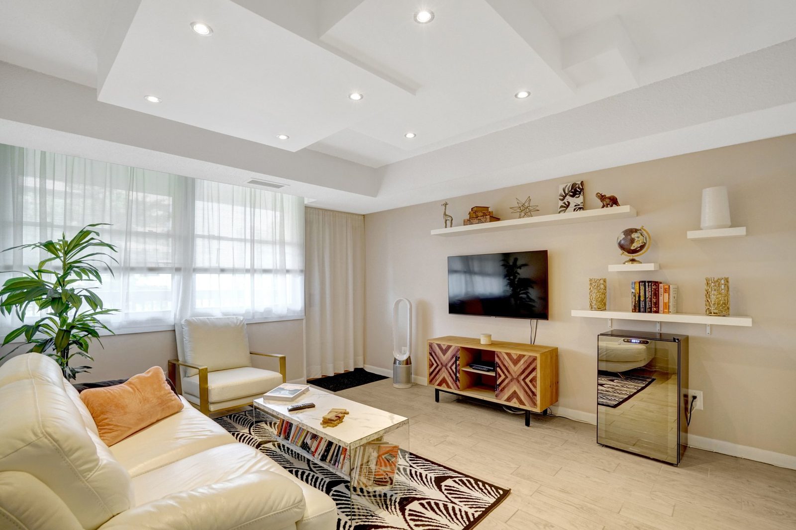 Living room with recessed lighting, floating shelves and light plank floors
