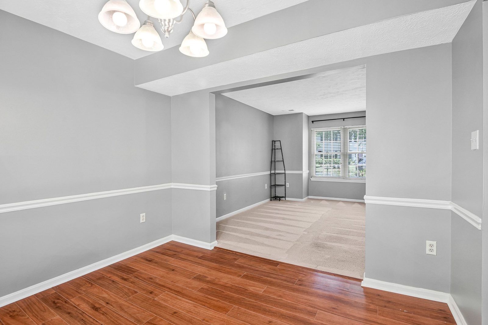 Dining room with chandelier opening to carpeted living room