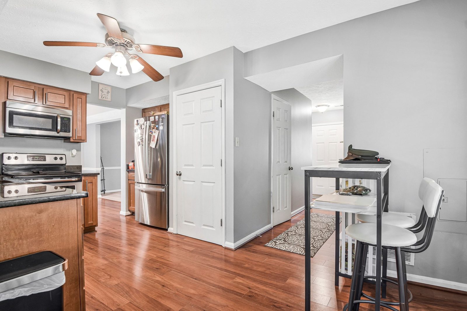 Kitchen with stainless refrigerator, range and doors to adjoining hall
