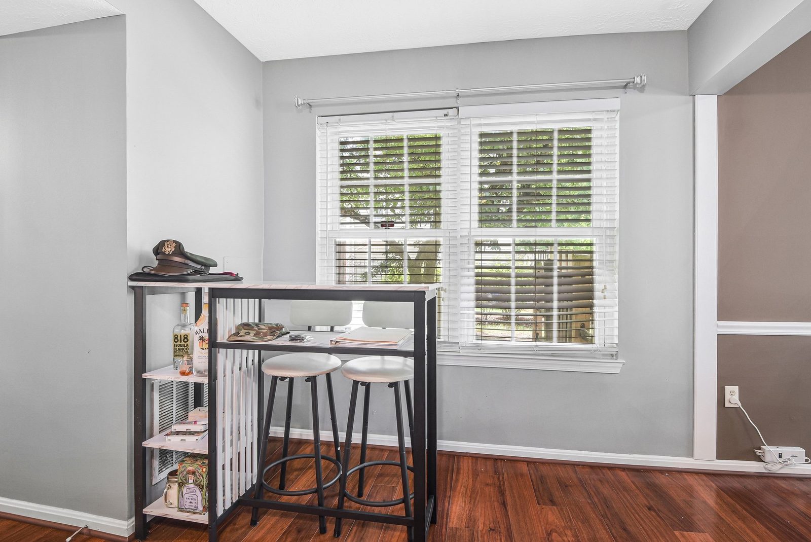 Corner breakfast nook with bar table, two stools and windows