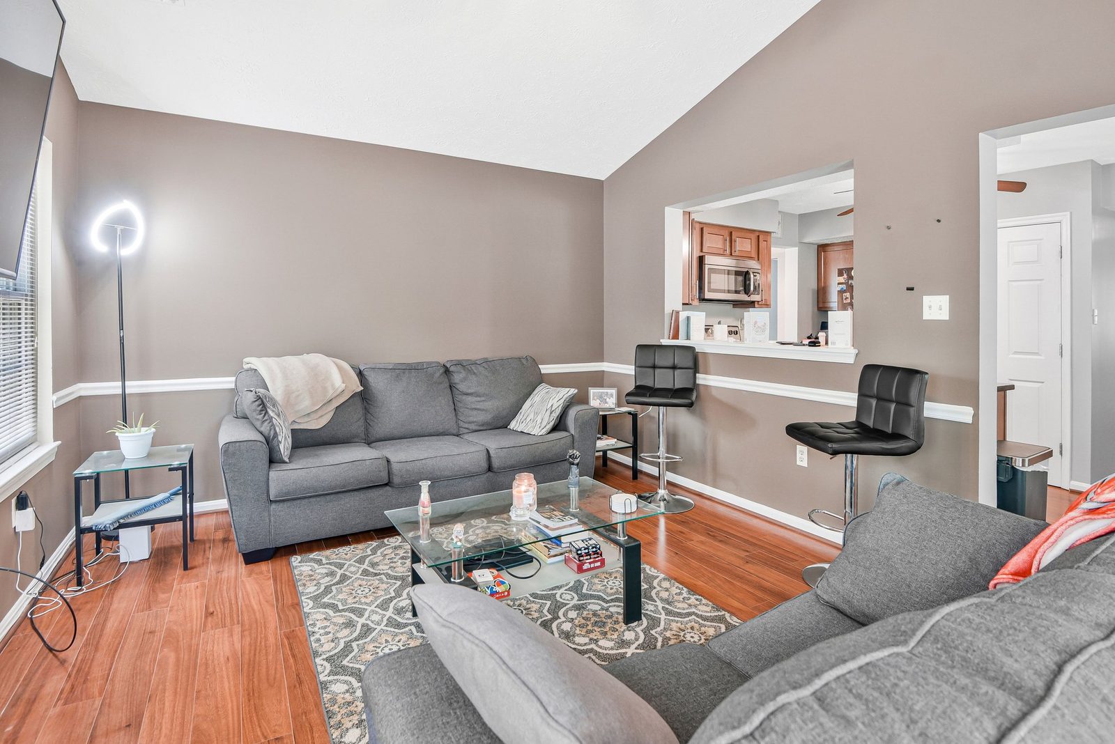 Living room with hardwood floors and breakfast bar open to kitchen