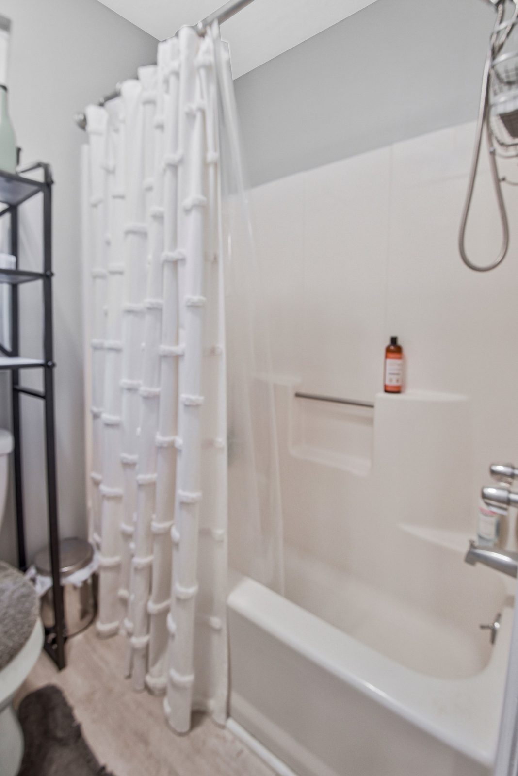 Tub and shower with white surround and shower curtain