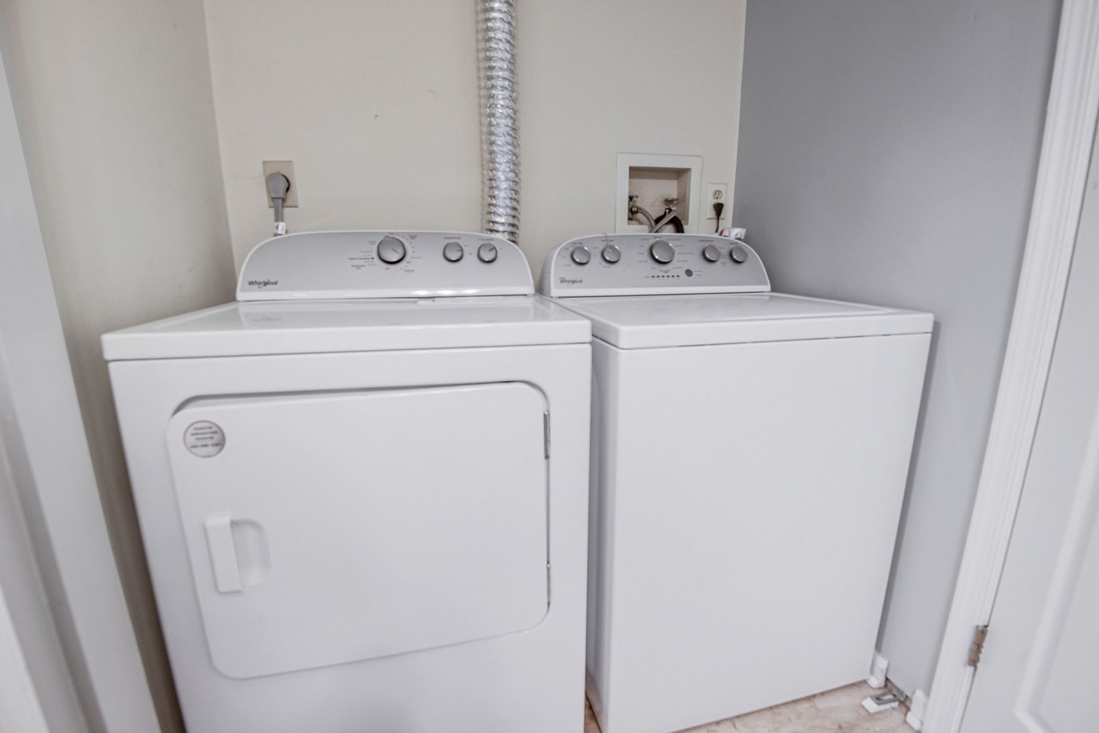 White washer and dryer side by side in laundry closet