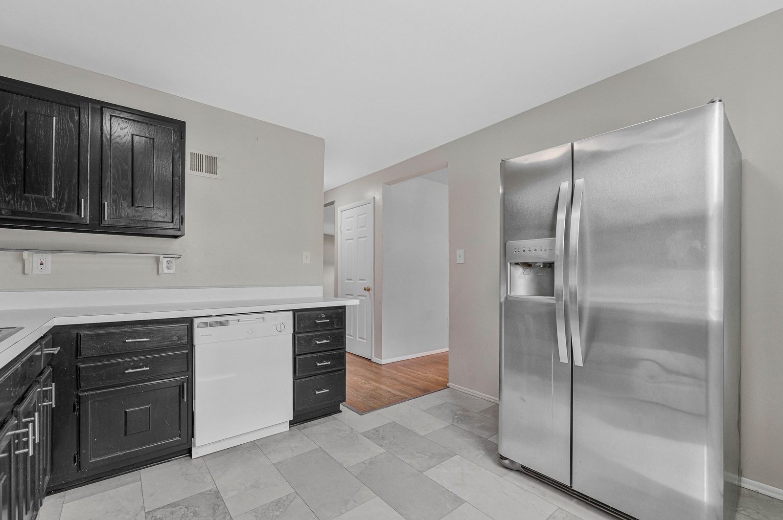 Kitchen with stainless side-by-side refrigerator and tile floor