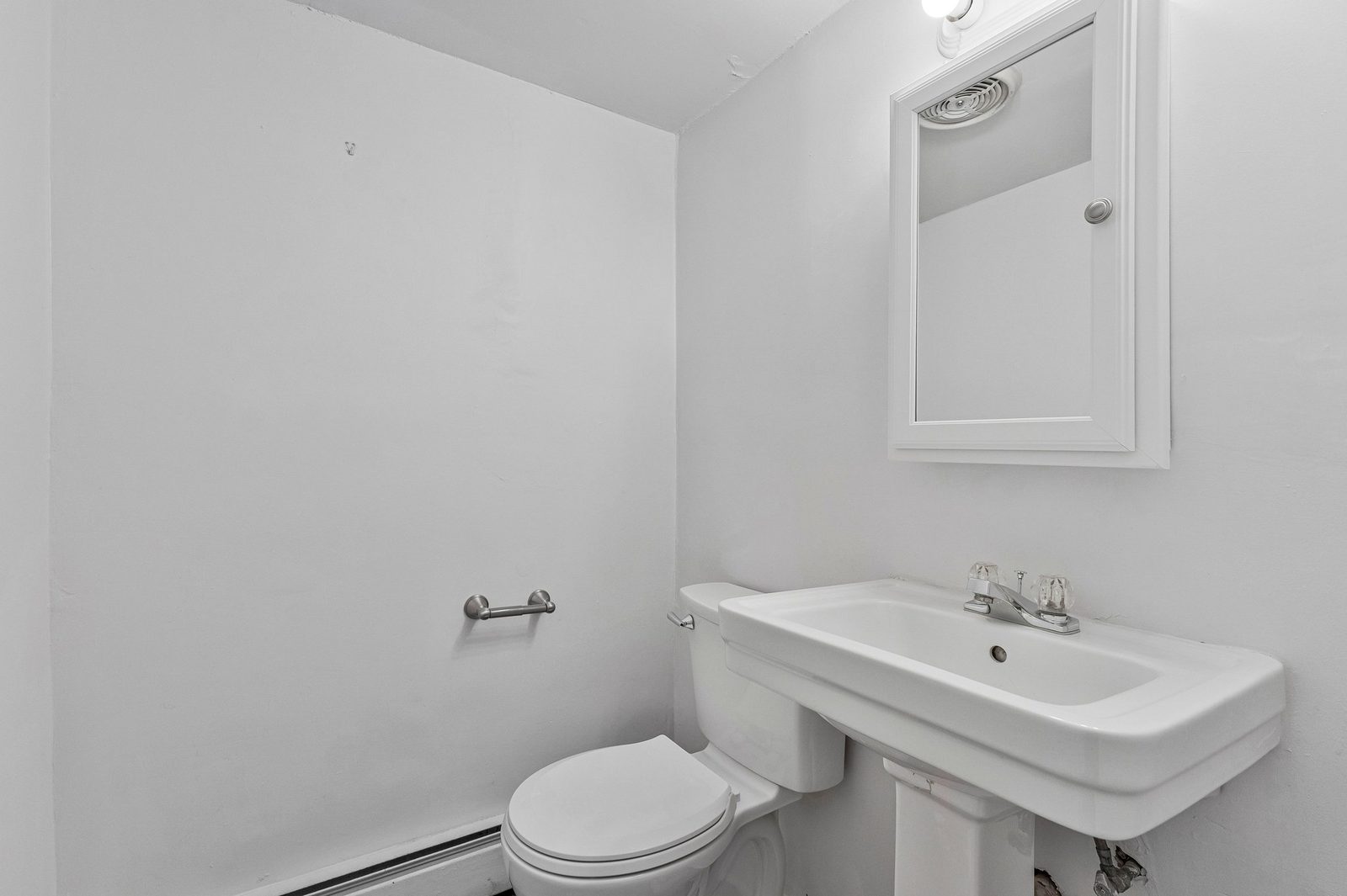 Half bath with pedestal sink, mirrored medicine cabinet and toilet