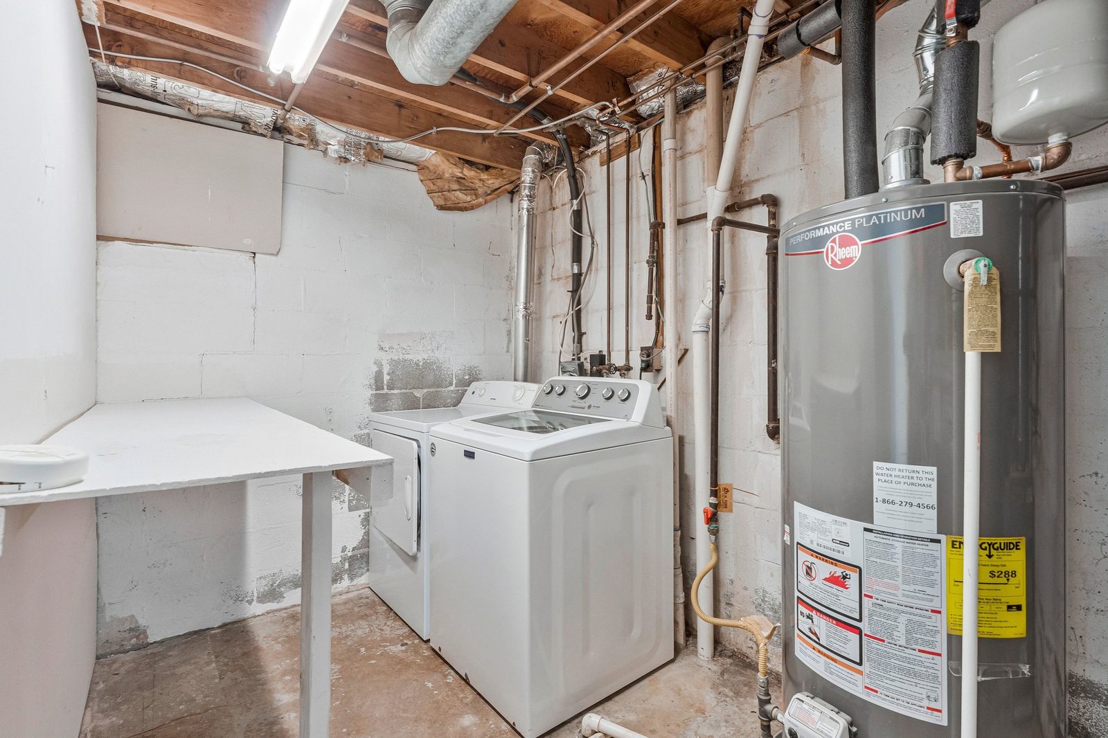 Unfinished laundry area with washer, dryer and water heater
