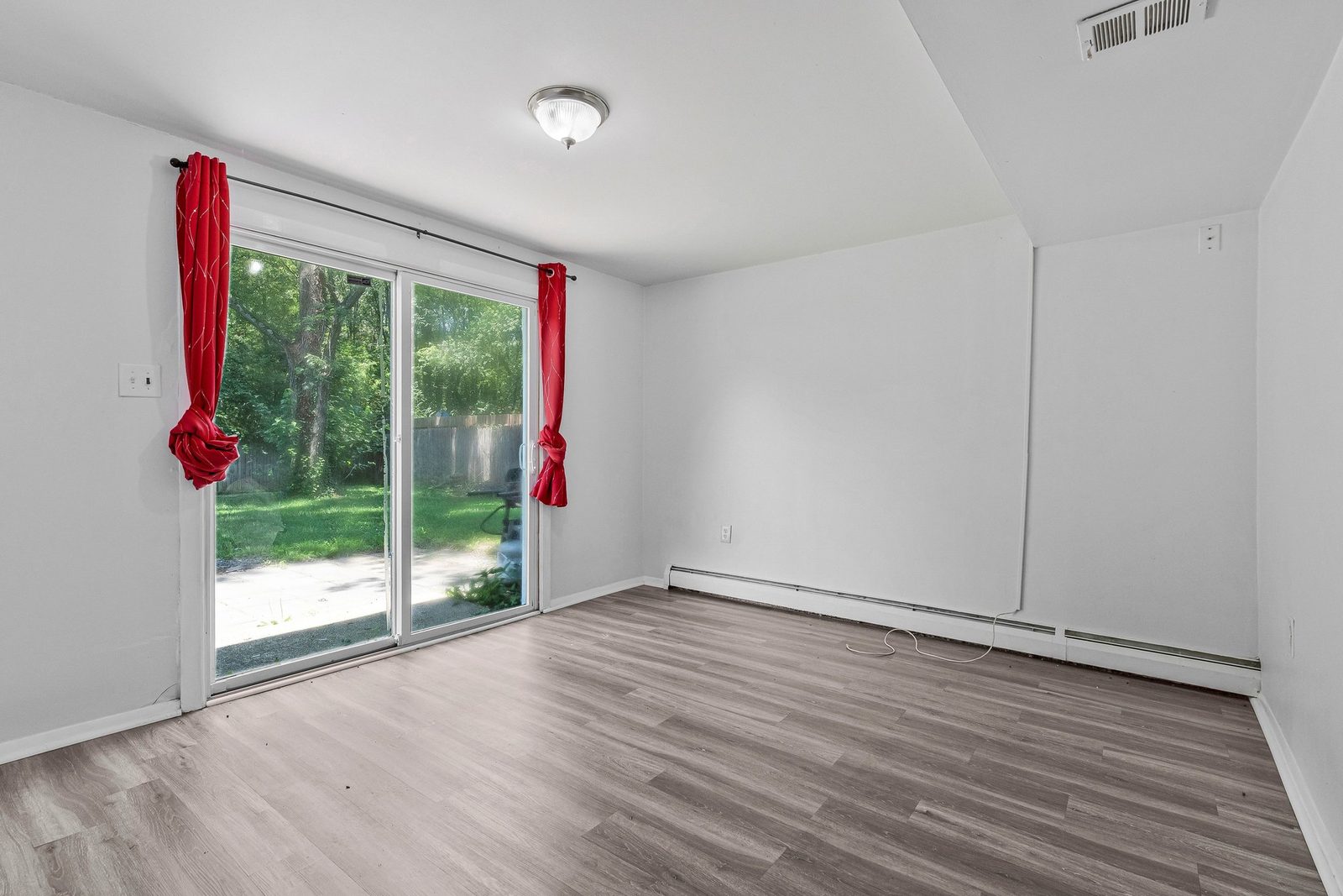 Room with sliding glass door to fenced back yard