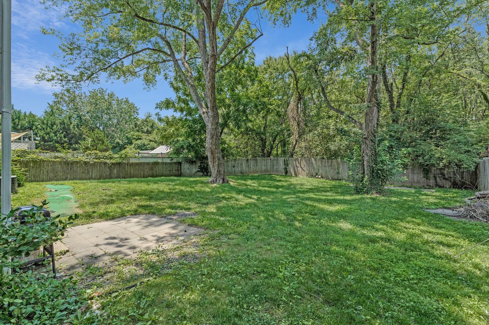 Back yard with paver patio, lawn and wood privacy fence
