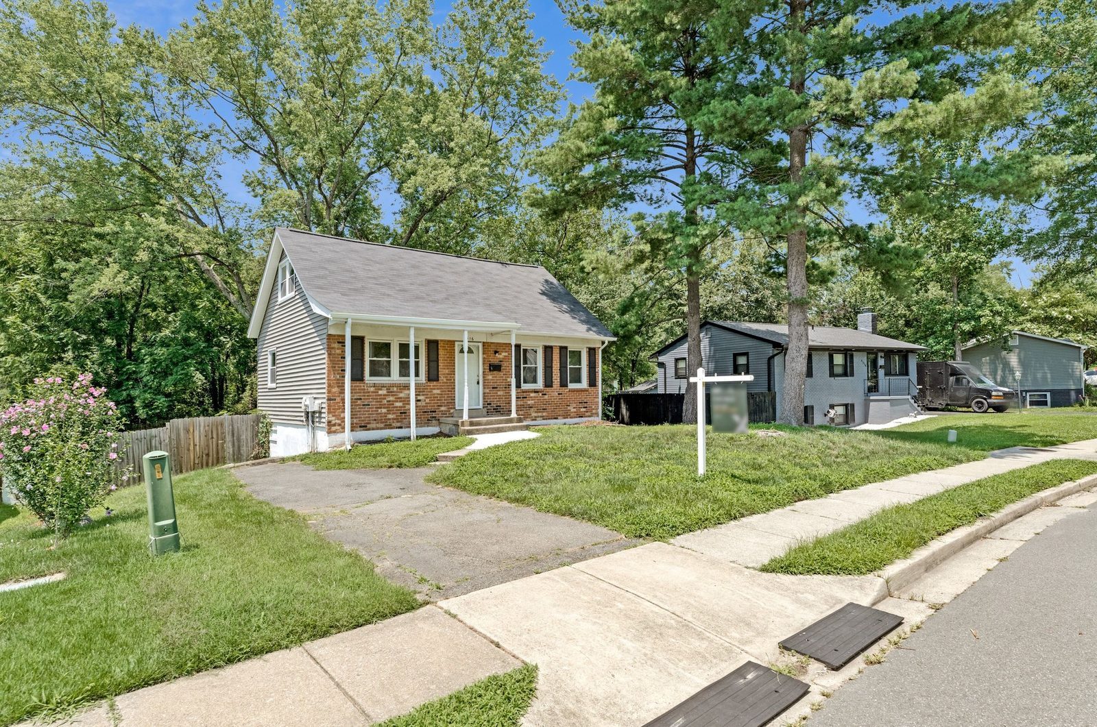 Brick front exterior with covered porch, driveway and front lawn