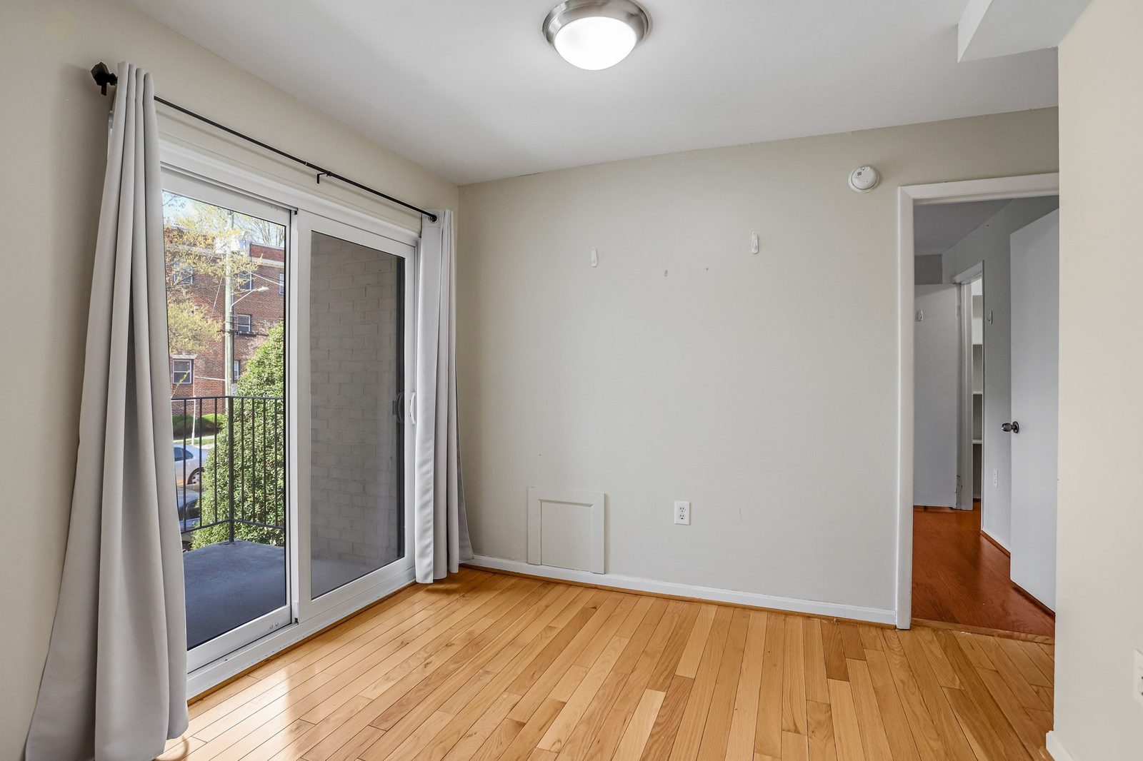 Room with sliding glass door to balcony with black iron railing