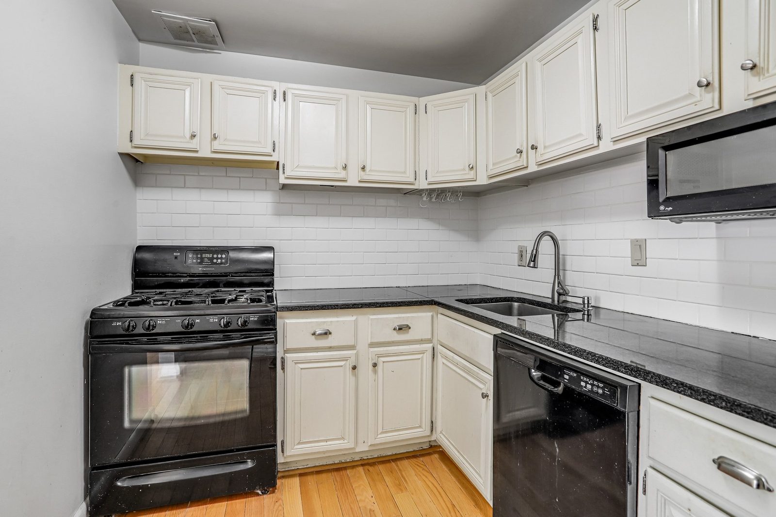 Kitchen with gas range, stainless sink and hardwood floor