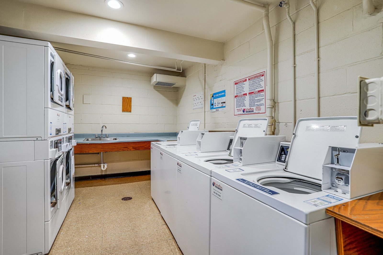 Shared laundry room with coin-operated washers and stacked dryers