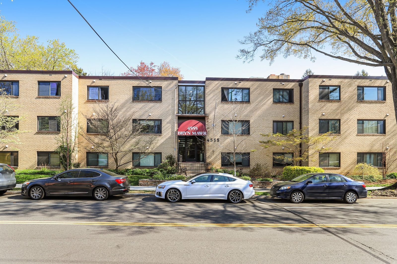 Three-story brick building facade with red entrance awning