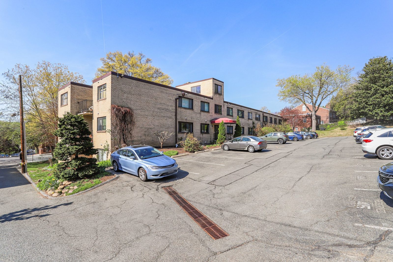 Rear parking lot beside brick building with landscaped beds