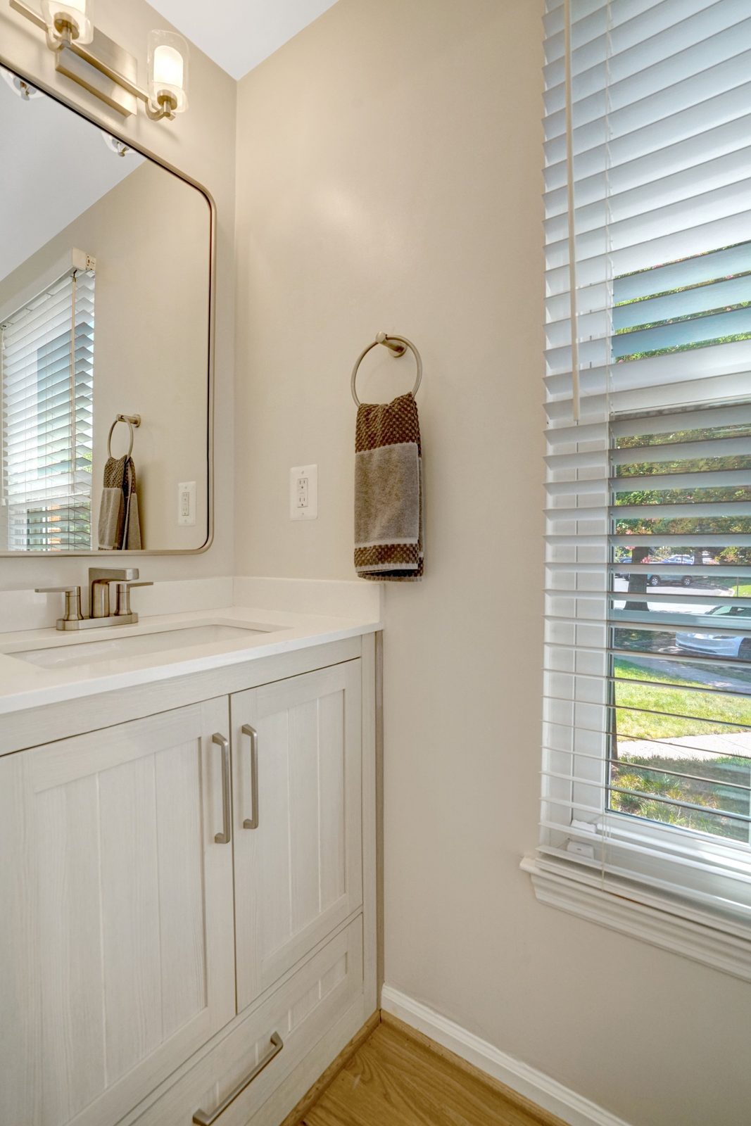 Vanity with framed mirror, vanity light and hardwood floor