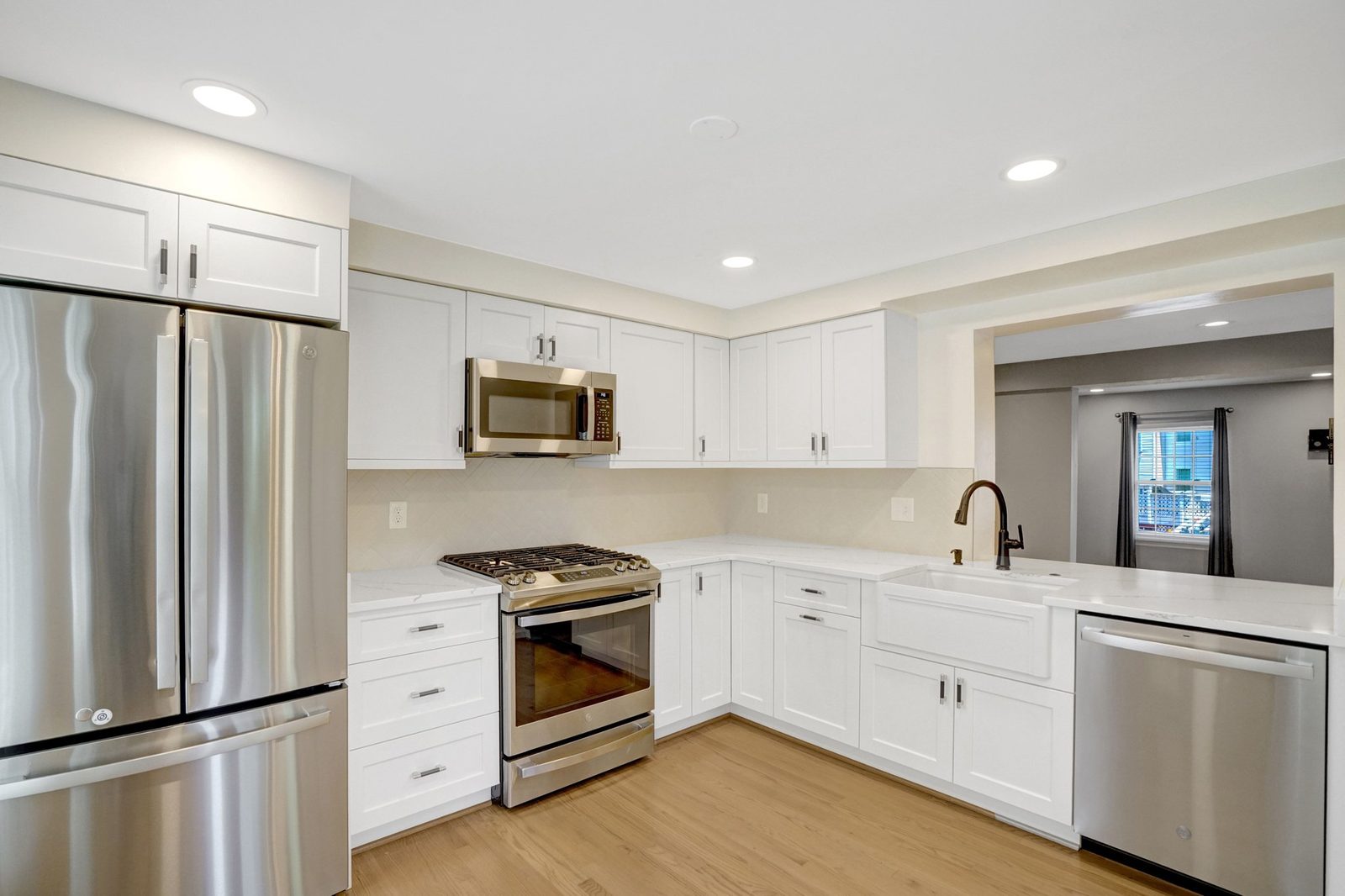 Kitchen with gas range, farmhouse sink and open pass-through counter
