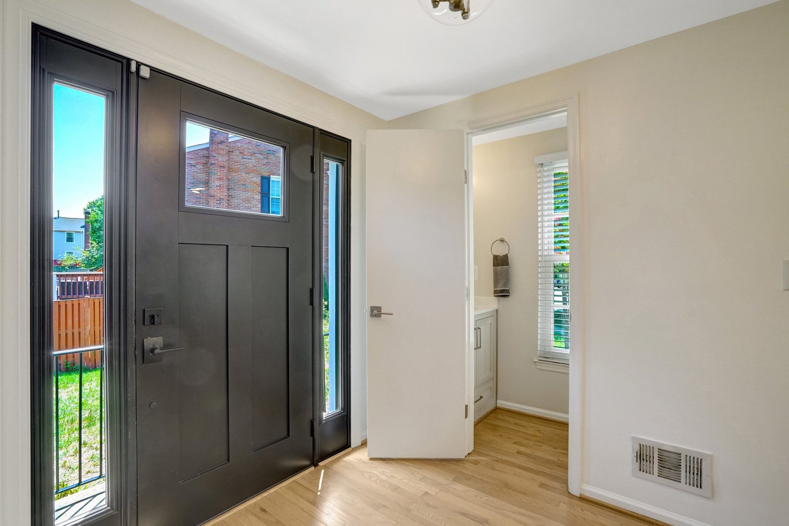 Entry hall opening to a bathroom with vanity and window