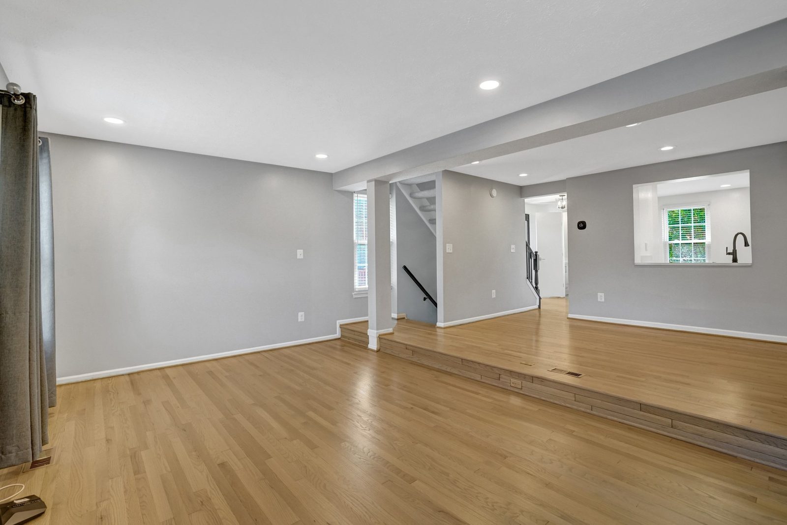 Wide living space with hardwood floors and step up to the entry