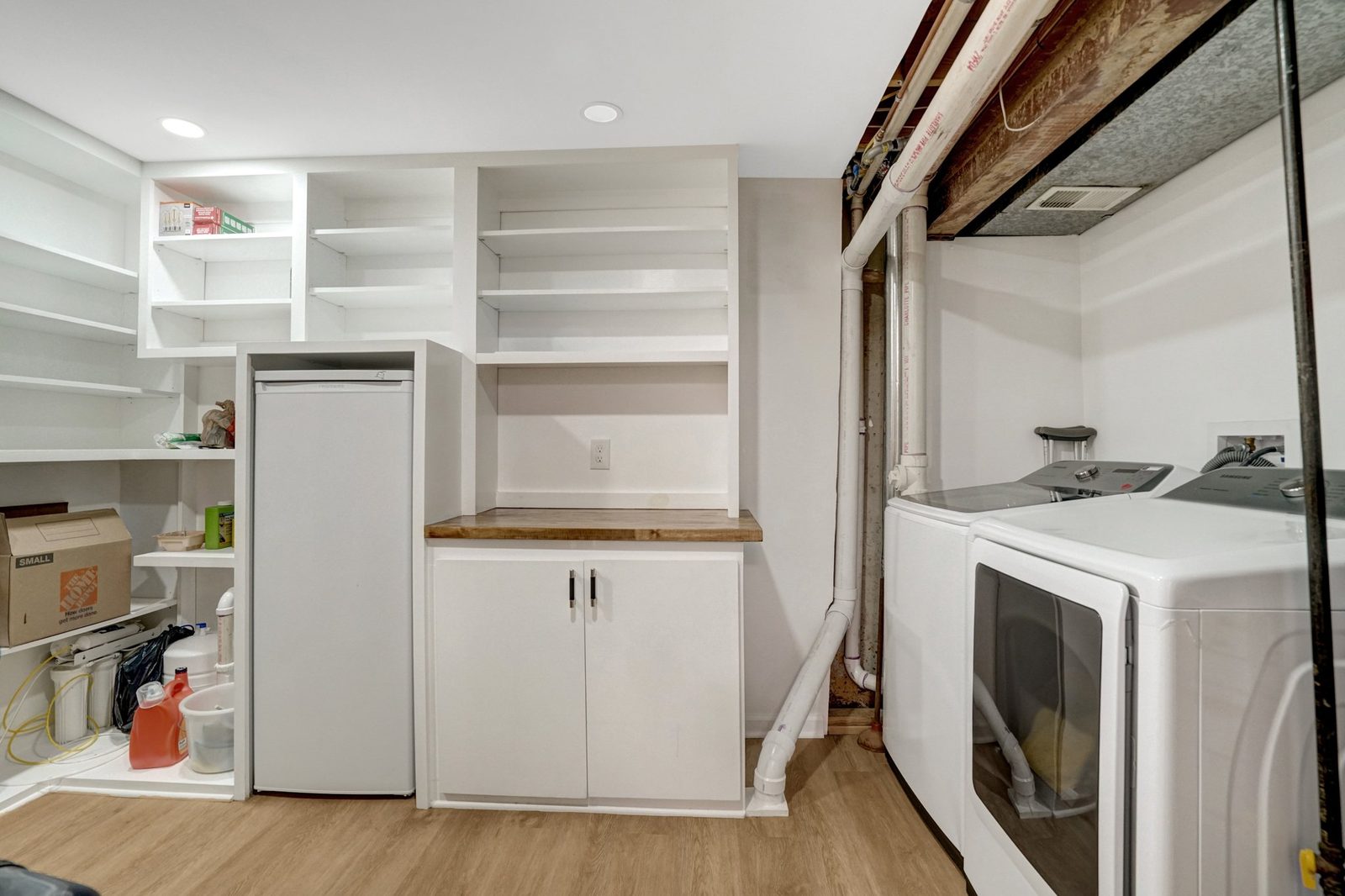 Laundry area with washer, dryer and white built-in storage shelving