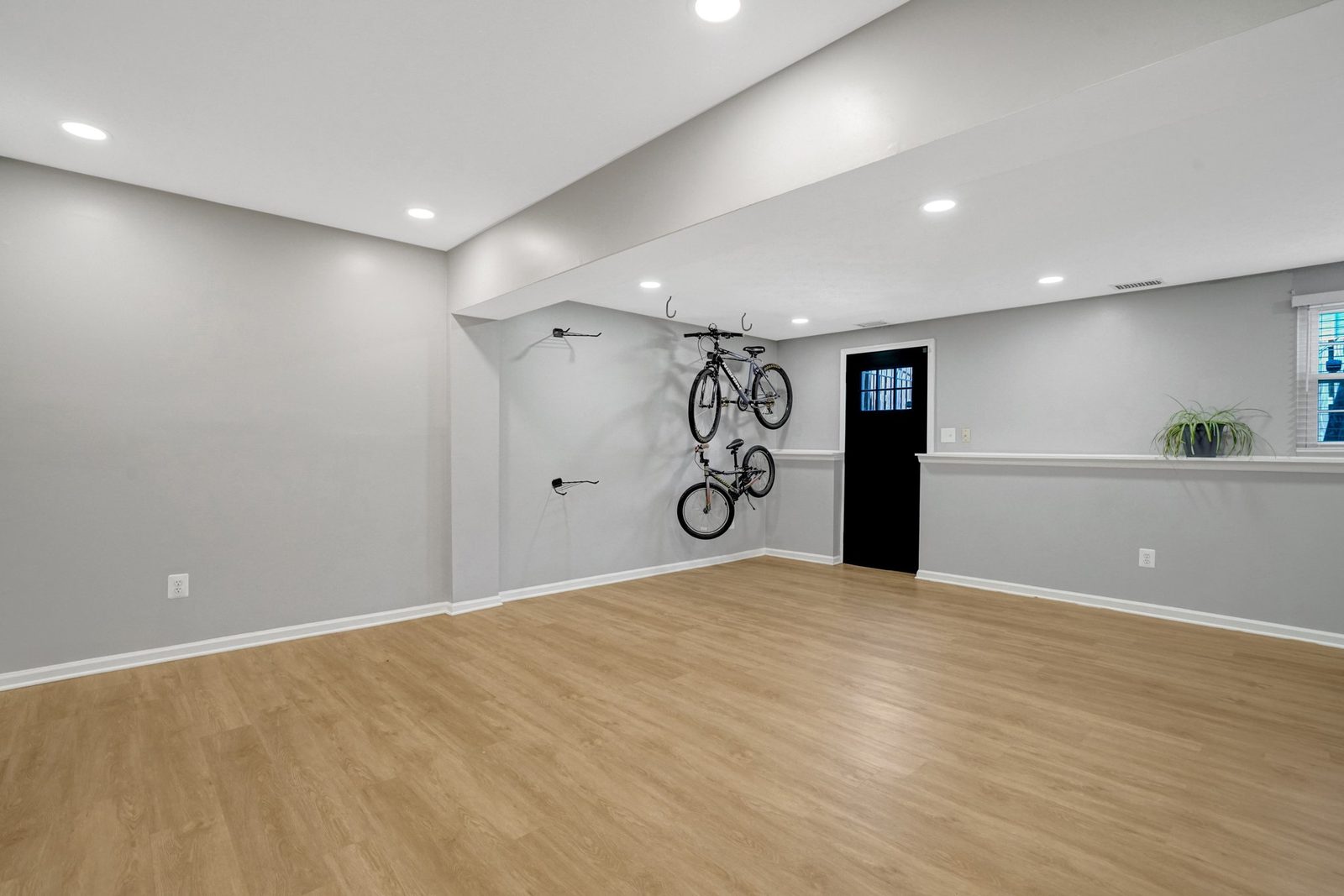 Finished lower level with wood-look plank floors and half-wall ledge