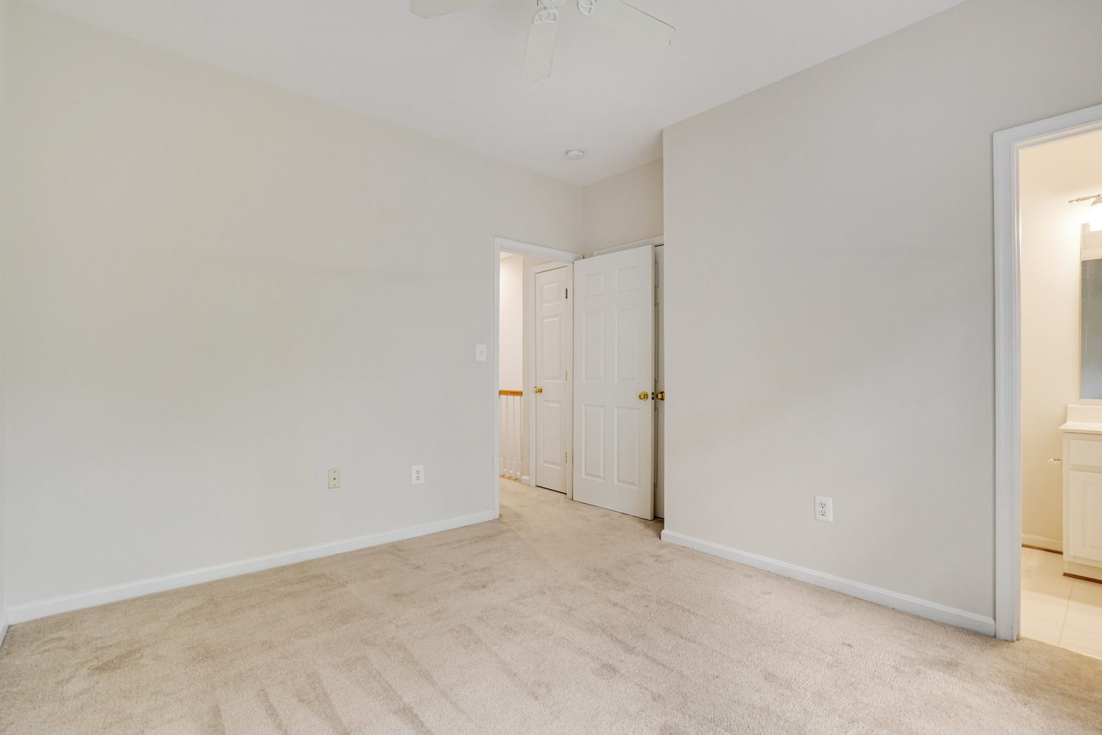 Carpeted room with doorway to hall and adjoining tiled bathroom