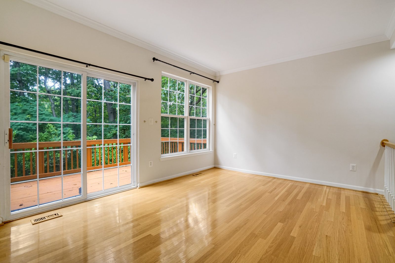 Hardwood-floored room with sliding glass door to wood deck