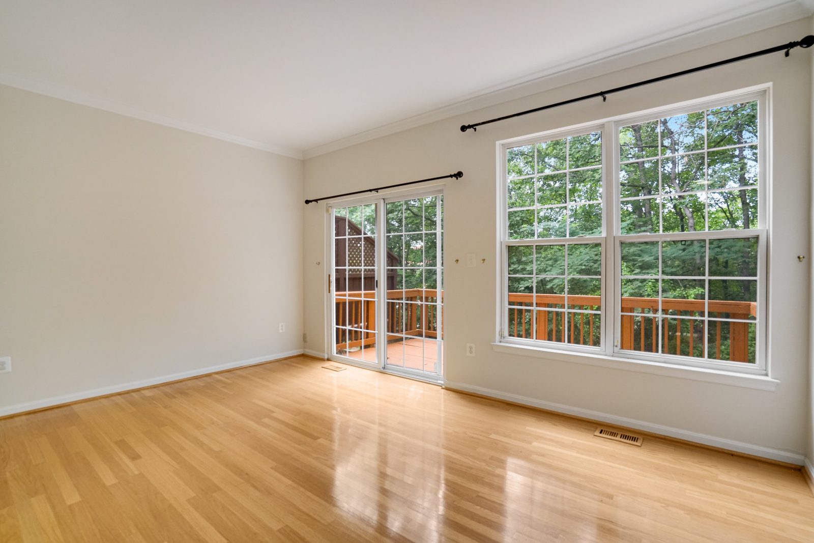 Bright hardwood room with sliding door to deck and large window