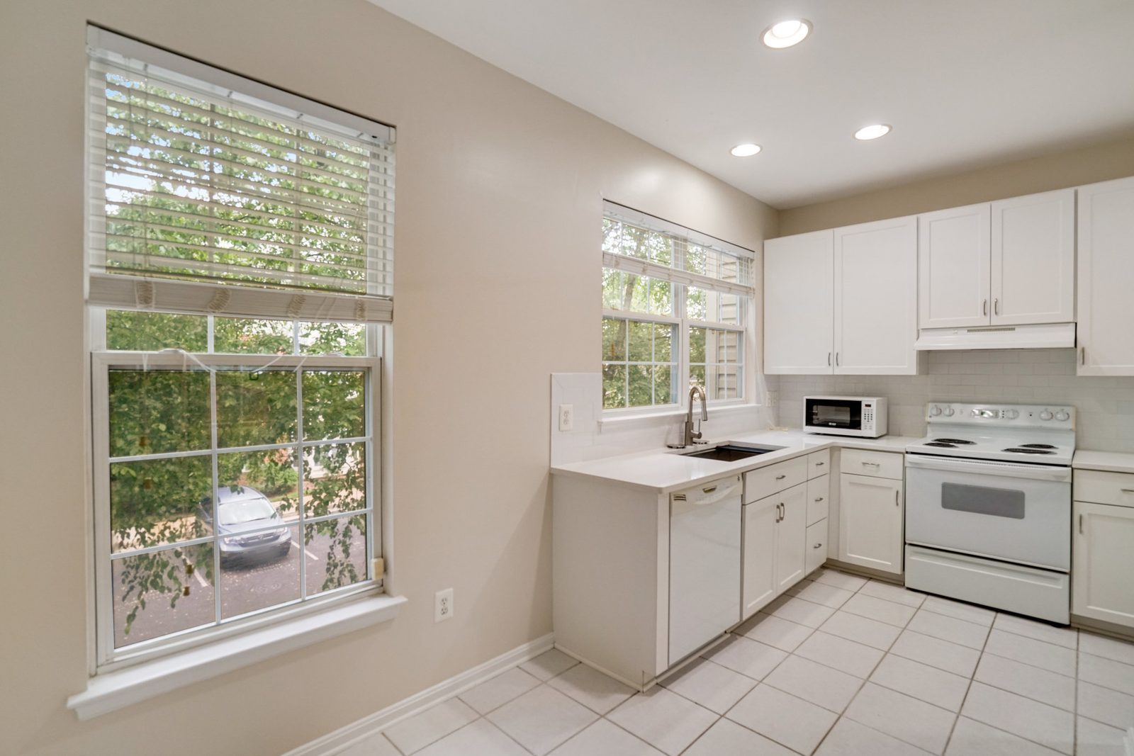 White kitchen with dishwasher, electric range and tile floor