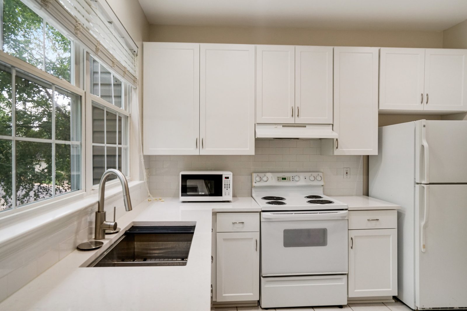 White shaker kitchen with subway tile backsplash and electric range