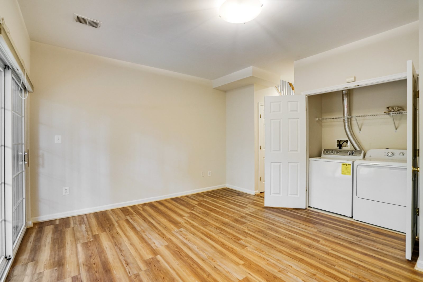 Room with plank floor and laundry closet with washer and dryer