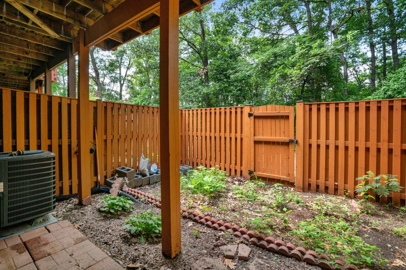 Fenced backyard with gate, paver patio and outdoor AC unit