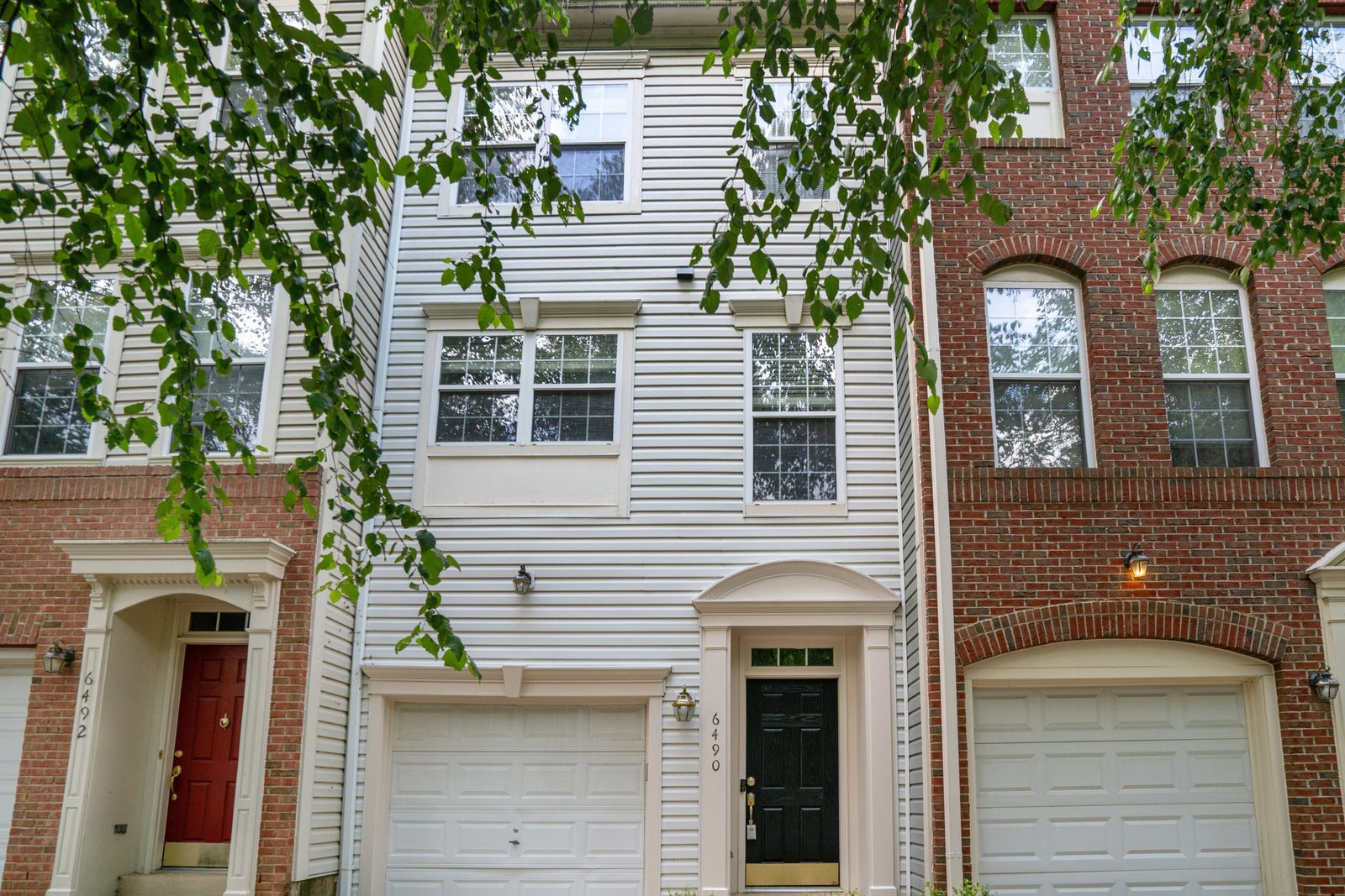 Front facade with black front door and white garage door