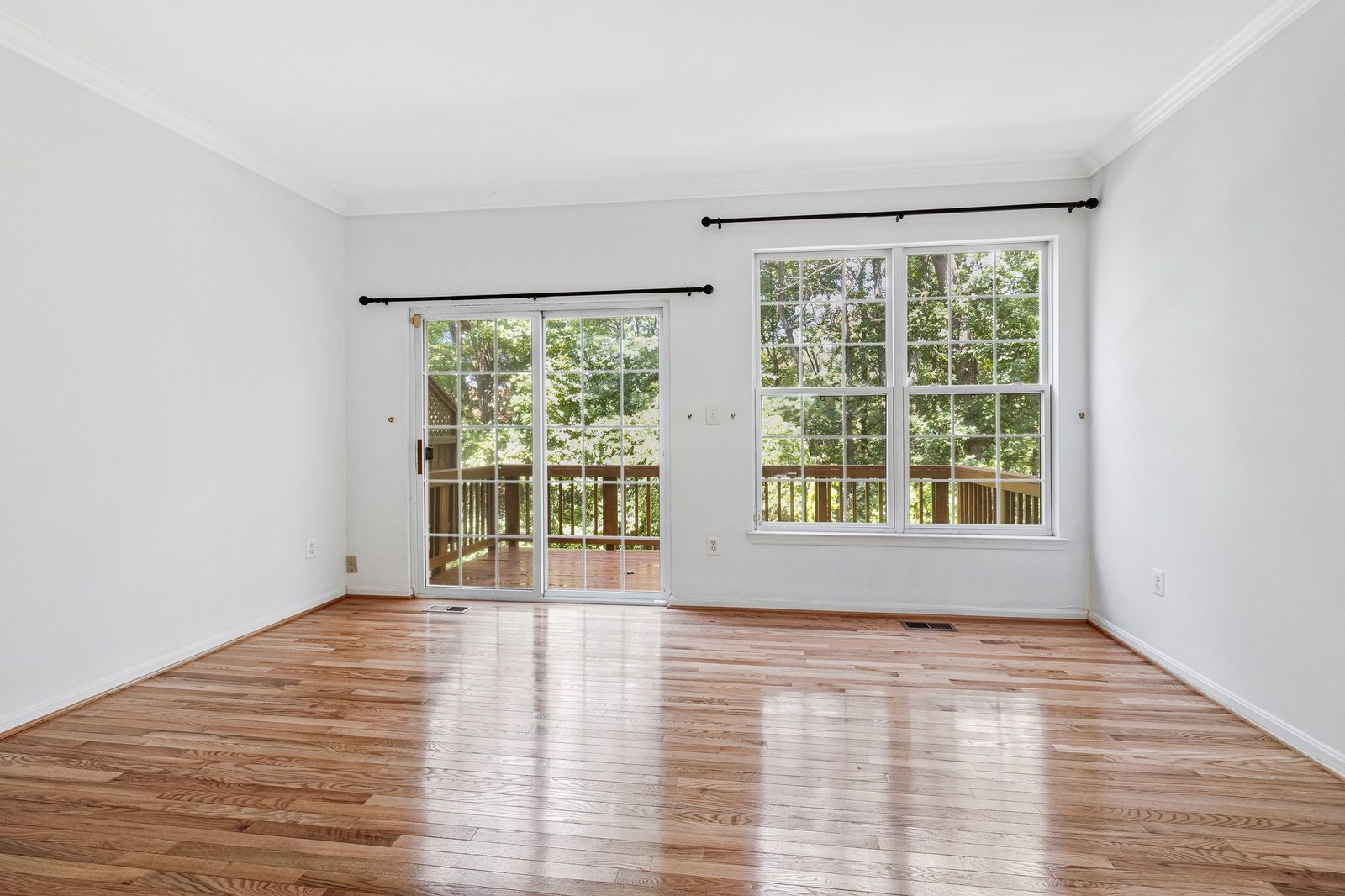 Empty room with crown molding, hardwood floors and sliding door to deck