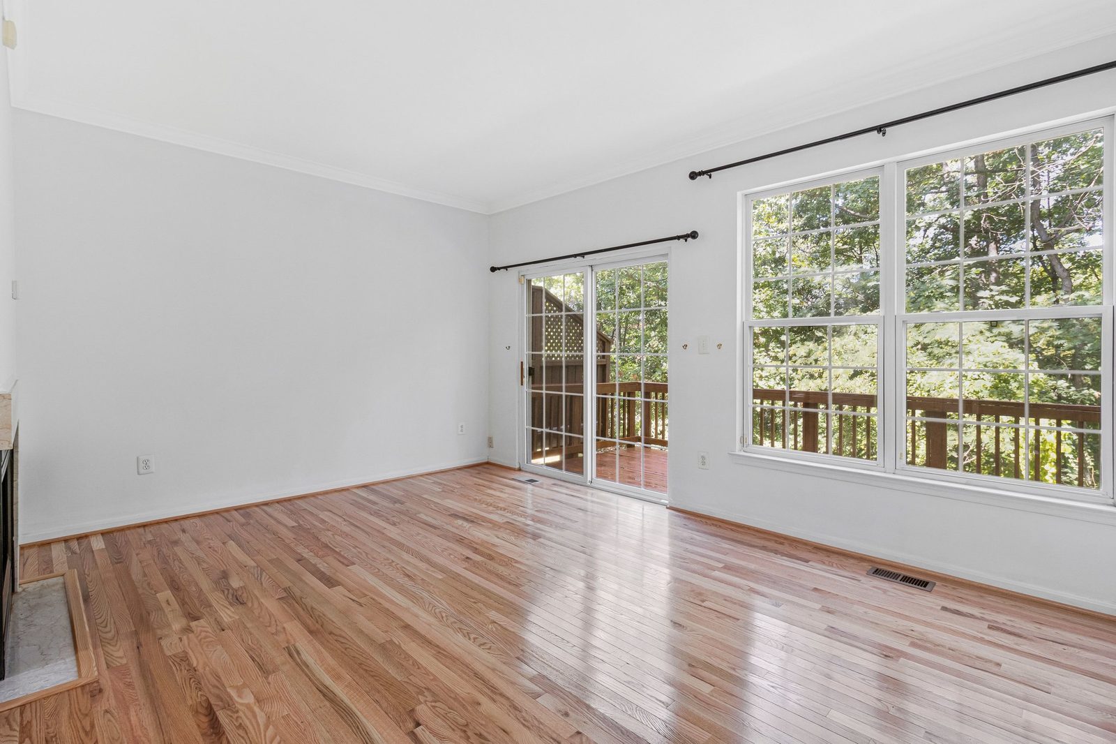 Hardwood room with sliding door to deck and treetop views