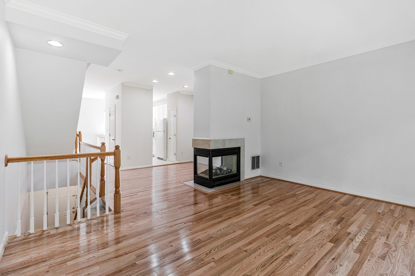 Open living area with three-sided fireplace and red oak floors